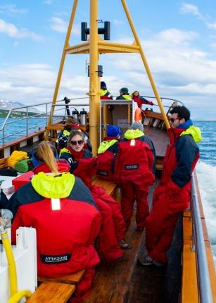 几个东北大学的学生穿着寒冷天气的装备坐在冰岛附近海域的一艘船上