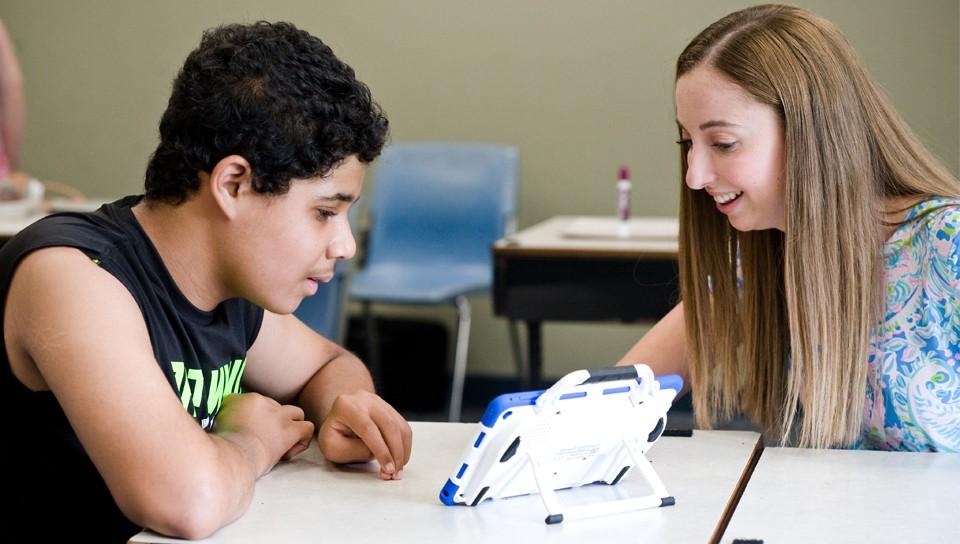 A U N E student specializing in special education helps a middle school student