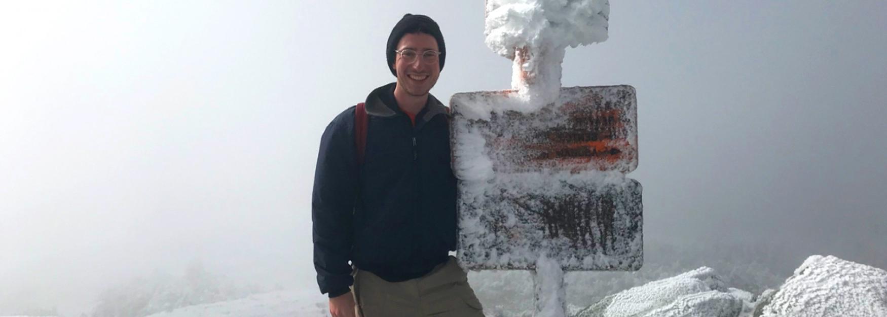 Mitchell Becker stands atop a snowy mountain in deep fog