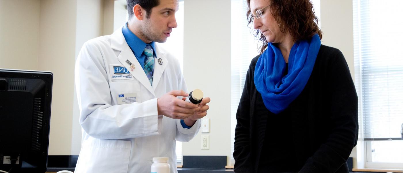 U N E pharmacy student shows a patient a prescription