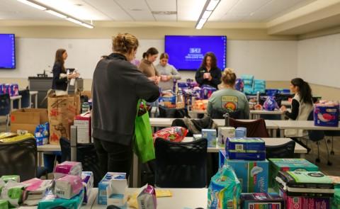 students filling kits full of reproductive health supplies