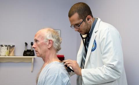A UNE medical student treats an older patient